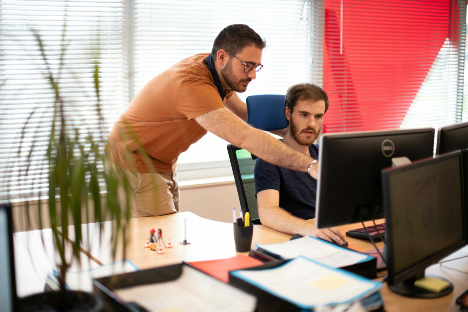 Deux techniciens analysent un PGOC (Plan Géoréférencé des Ouvrages Construits) sur écran dans un bureau, en contexte de projet d’ingénierie ou de travaux publics.