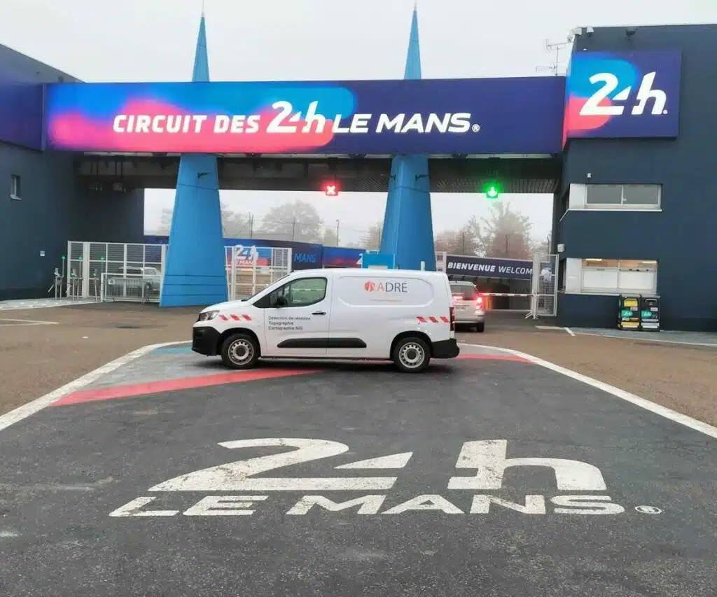 Un camion d'intervention d'ADRÉ Réseaux est garé devant l'entrée du circuit des 24 Heures du Mans.